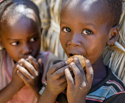 Two Childrens are eating some nuts.