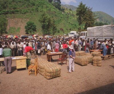 People in Rwanda stand on a hillside with the few possessions they could salvage