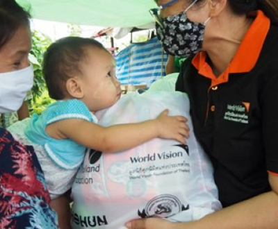 A worldvision employee giving something to a child