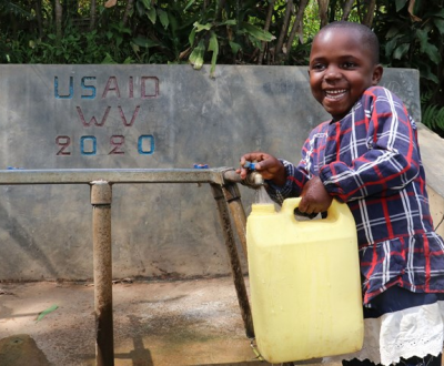 Child collecting water from a tap