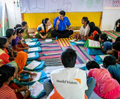 World Vision staff members and community sit down together having a discussion in Bangladesh