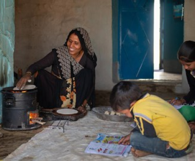 Rajkumari from India with her children, Rishab and Roshni, using fuel-efficient cookstoves