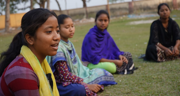 Some womens are sitting in the field.