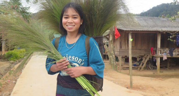 Girl from Vietnam holding some branches.