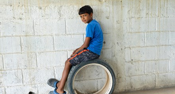 Boy sitting on a wheel