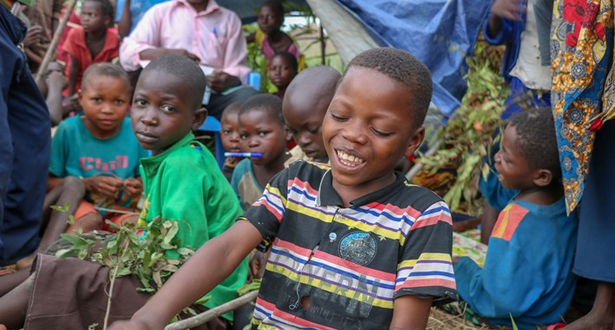 A child, surrounded by others, works on puzzles in one of four Child Friendly Spaces established in Democratic Republic of Congo