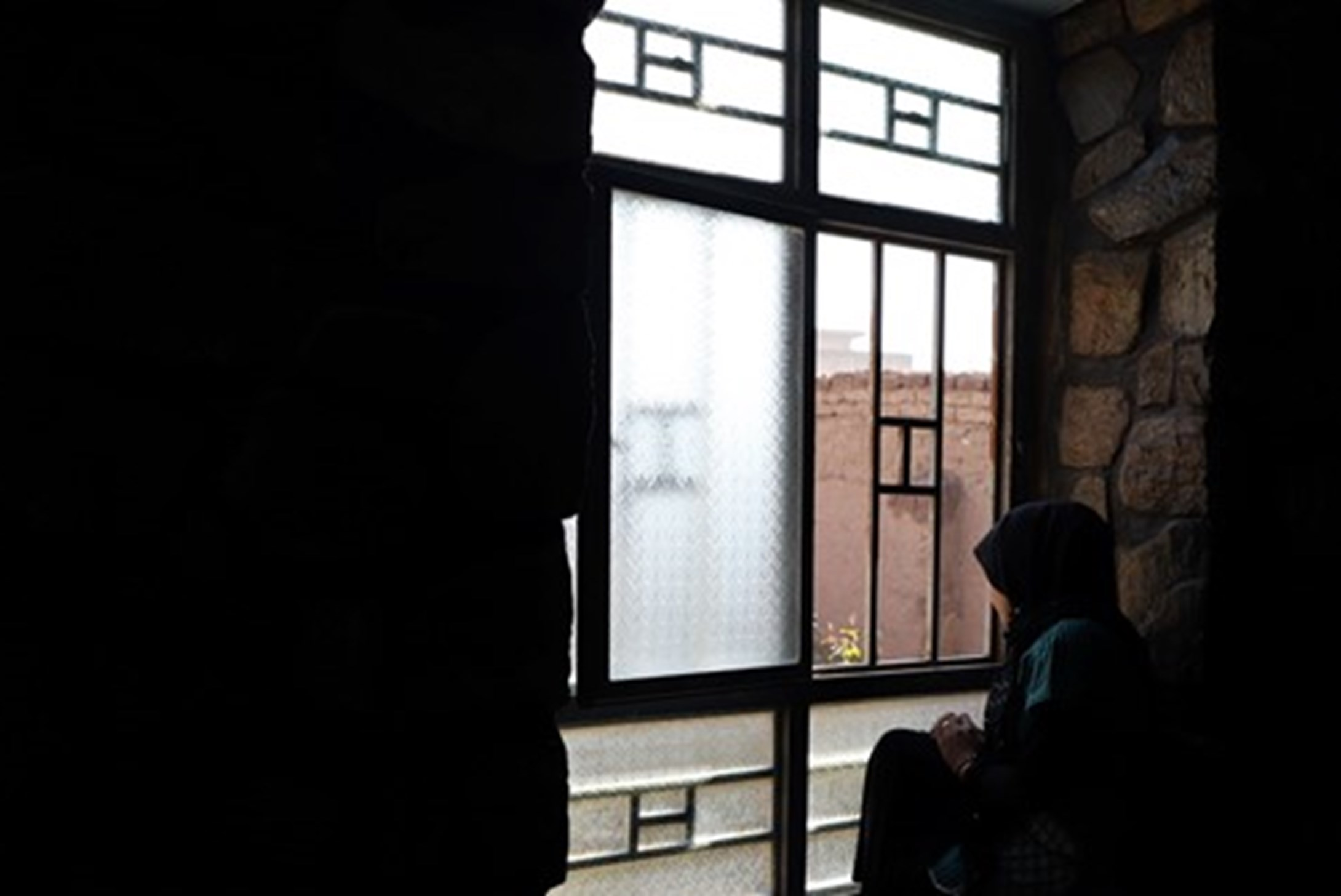 afghanistan woman sitting by the window