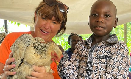 A women and a boy with a chicken.