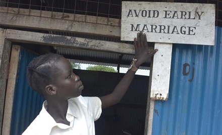 A girl looking to a board says, avoid early marriage