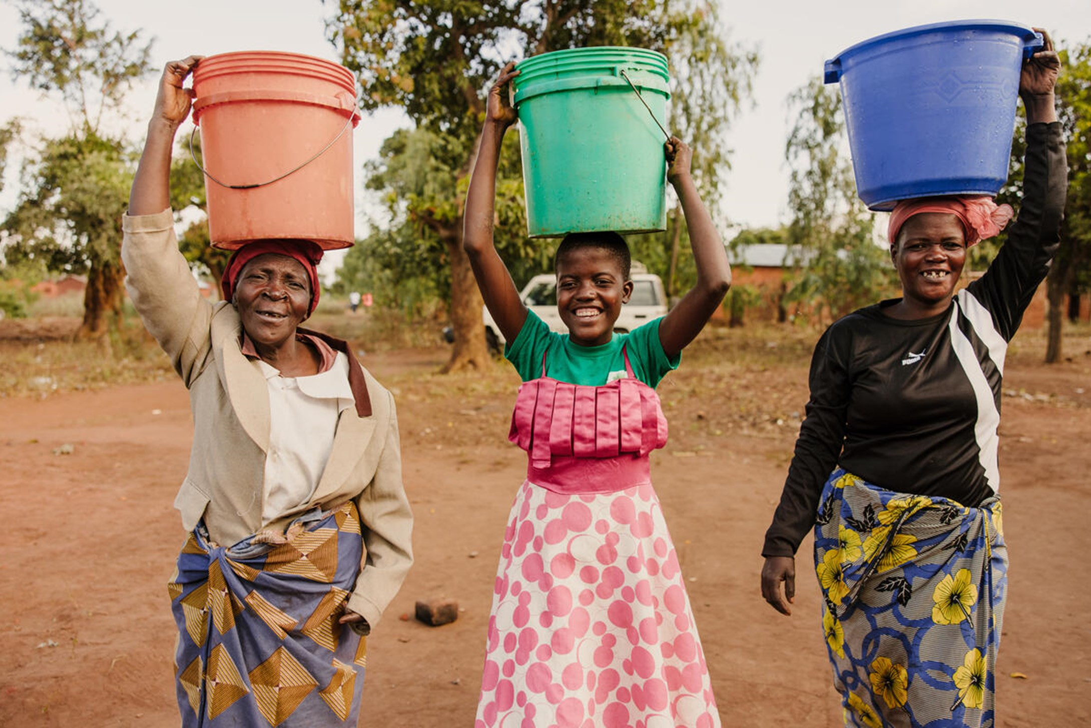 Leon and other women carrying buckets of water in their head