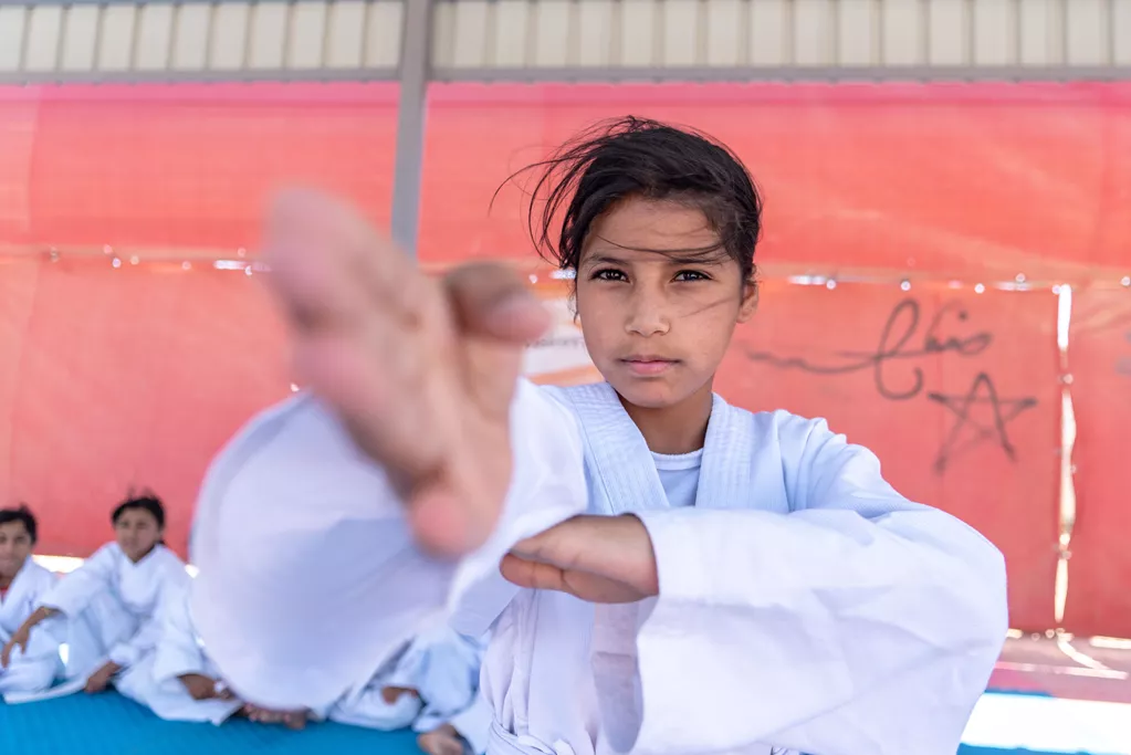 A Syrian girl shows her technique to the camera as she takes part in a karate class in Jordan's Azraq refugee camp