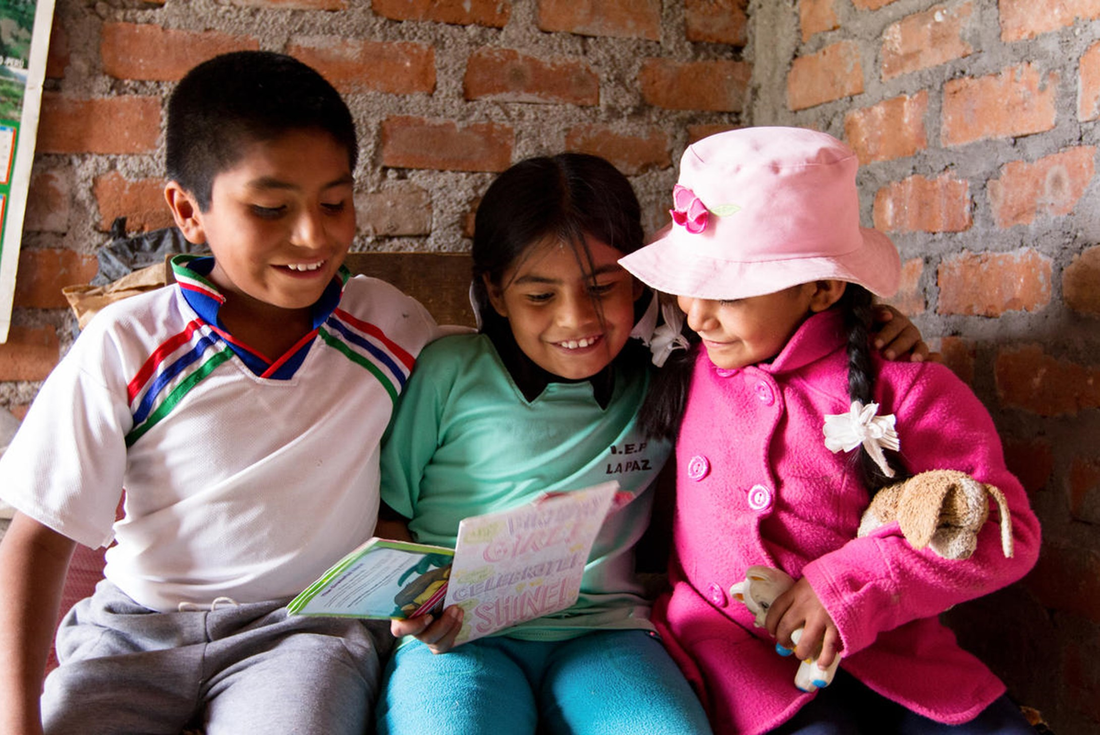 World Vision's sponsored child, Pedro, from Peru and his siblings reading the sponsor's letter