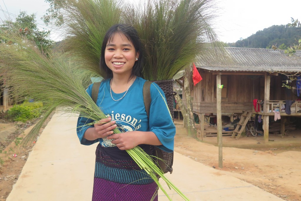 Girl from Vietnam holding some branches.