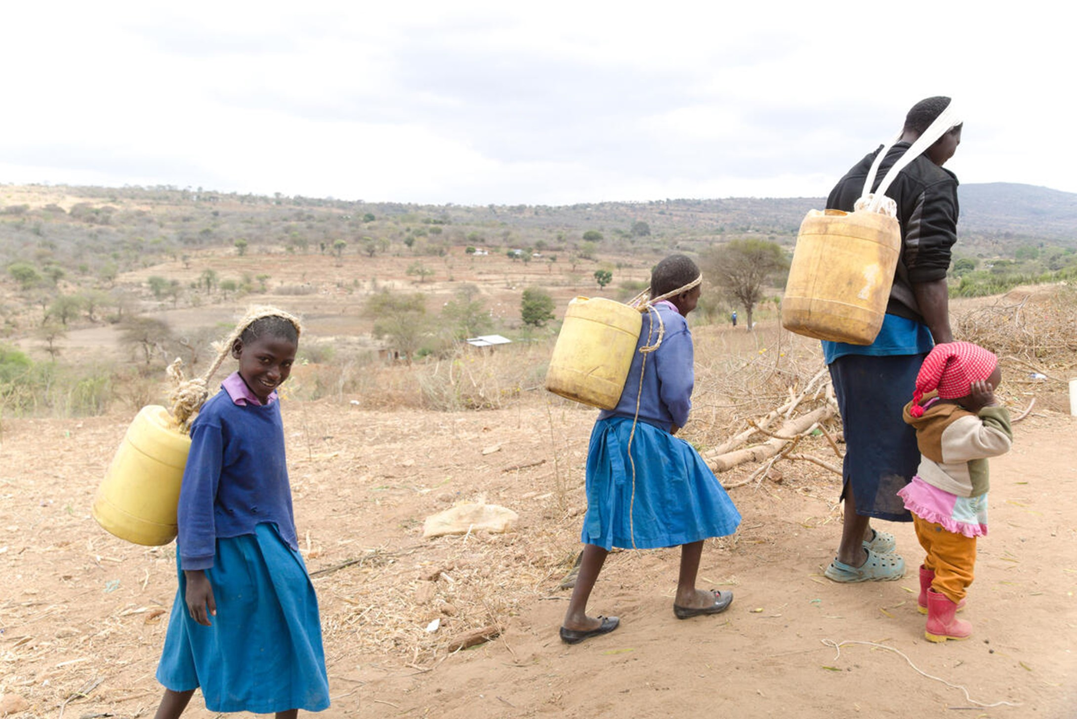 Anastacia, from Kenya, and her daughters travel long distance to collect water during drought