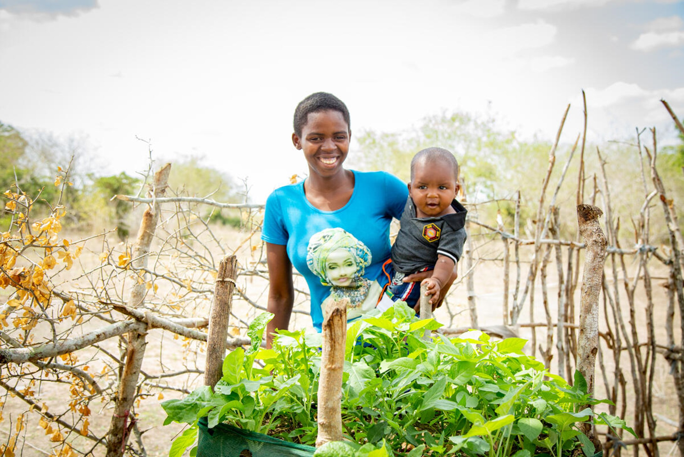 Catherine and her son Lawrence pose next to their kitchen garden in Marafa, Kenya