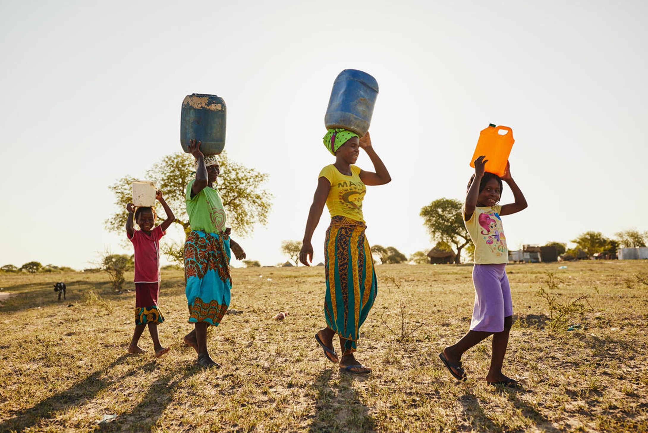 Children carry clean water home from their schools in Mozambique.