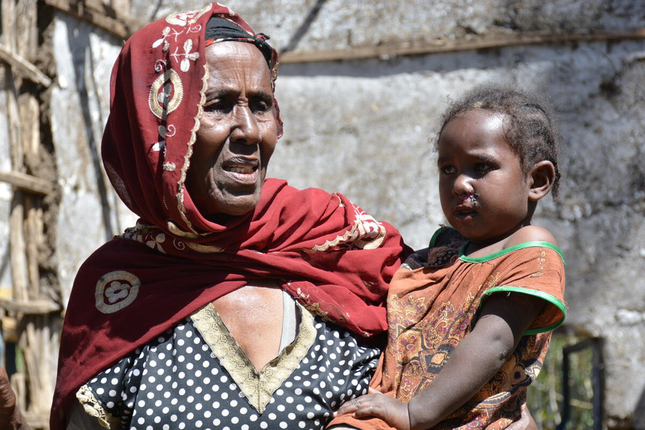 Ameto with her grand kid (Hayat ) at the middle of her destroyed shelter.