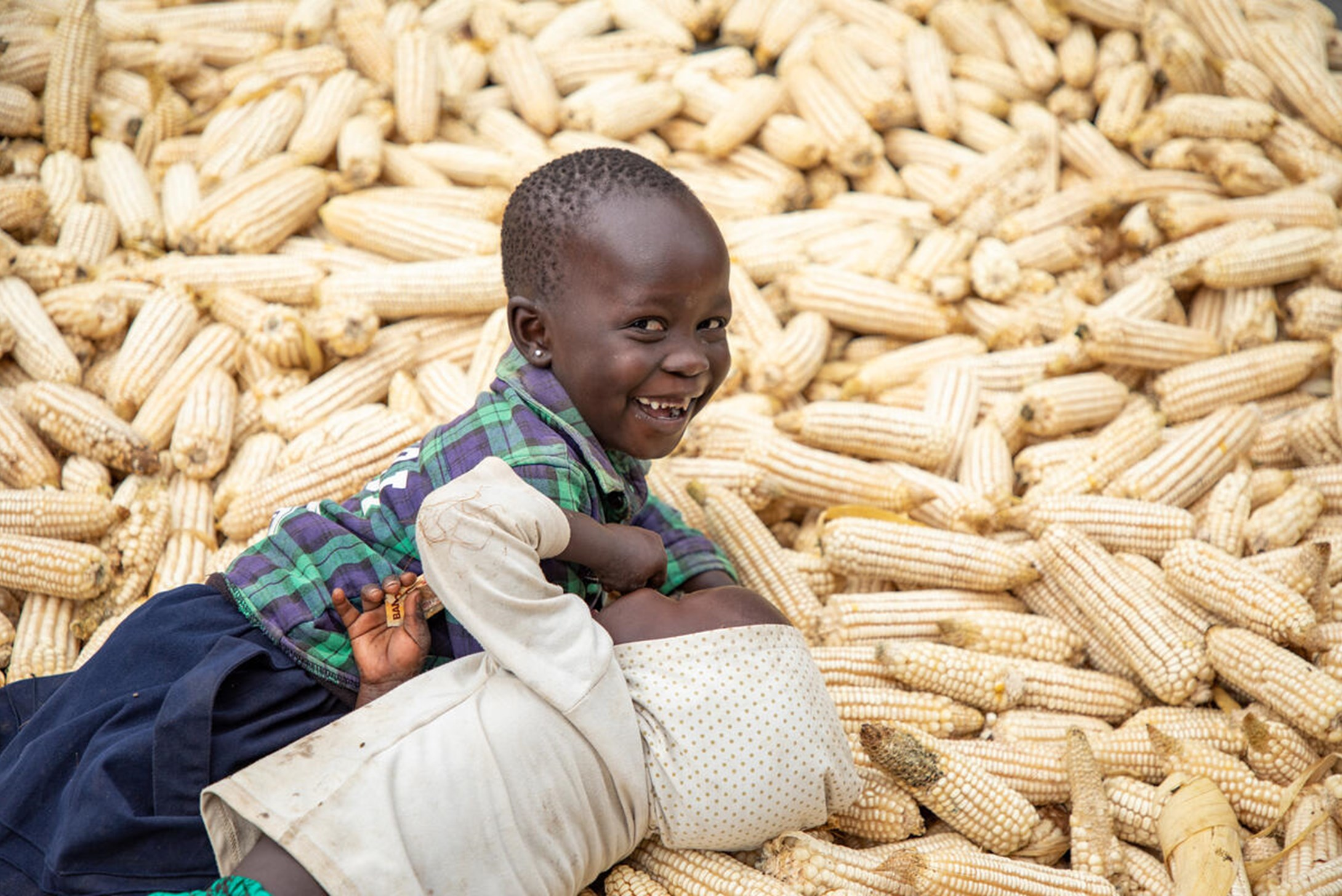 5-year-old Denis and his elder sister Mary from Uganda over the maize harvest