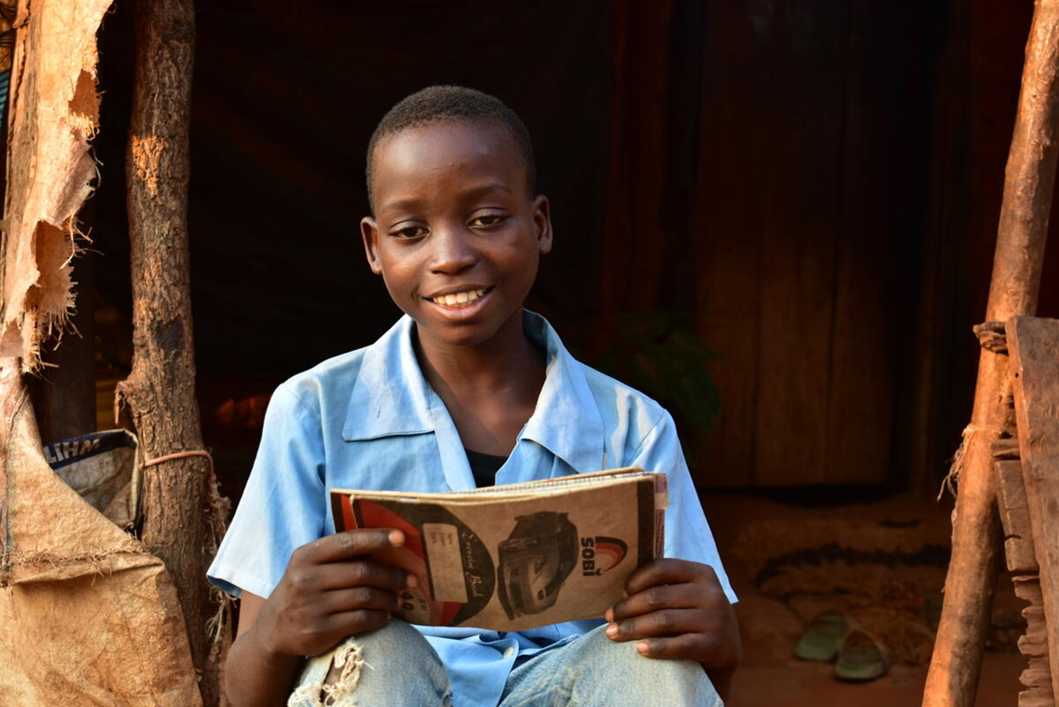 A boy sitting with a book in his hand