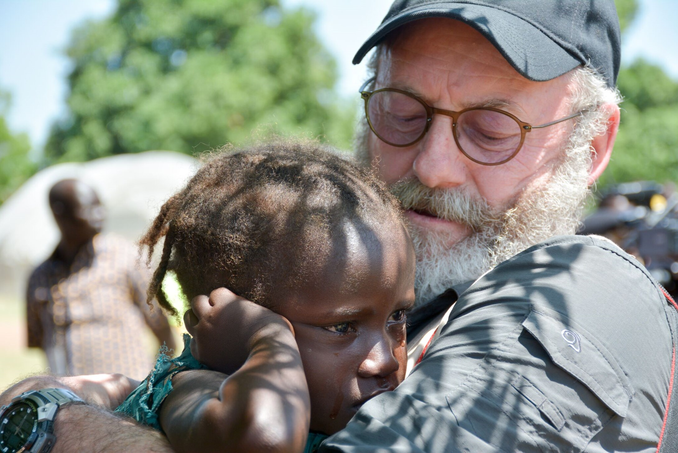 Liam Cunningham holding a little girl in Africa 